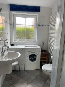 a bathroom with a washing machine and a sink at Deichbrise in Greetsiel +18 photos