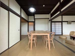 a dining room with a wooden table and chairs at 【 円 madoka 】逗子鎌倉で暮らすように過ごす一棟貸し宿泊施設​ in Zushi