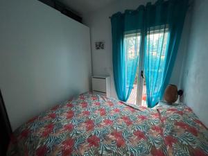 a bedroom with a bed and a window with blue curtains at Encanto Apartamento Sol Andalusí in Alhaurín de la Torre +5 photos