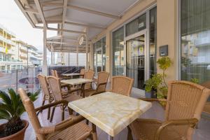 a row of tables and chairs on a patio at Abc Hotel in Rimini