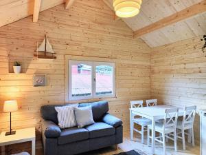 a living room with a couch and a table at Tiny houses Liv & Lea in Listerby