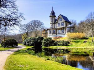 a large house with a tower on top of a lake at Tiny houses Liv & Lea in Listerby