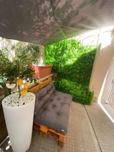 une petite cour arrière avec un canapé et une haie verte dans l'établissement The Green House, à Rome