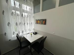 a table and chairs in a room with a window at Paky Appartements 00210 in Vienna