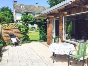 a patio with a table and chairs next to a house at Bungalow "Ostseehus" in Grömitz