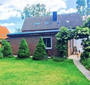 a brick house with trees in the yard at Bungalow "Ostseehus" in Grömitz