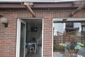 Bungalow "Ostseehus" في Grömnitzerhagen: باب مفتوح لبيت من الطوب مع فناء