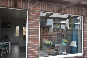 Bungalow "Ostseehus" في Grömnitzerhagen: منزل من الطوب مع نافذة وغرفة طعام