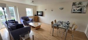 a living room with a couch and a table with chairs at SAV Apartment one bed Flat Uxbridge in Uxbridge
