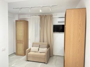 a living room with a chair and a television at Potami Seashell in Himare