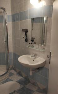 a bathroom with a sink and a shower at Hotel Merkur in Kaluža