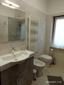 a white bathroom with a sink and a toilet at La casa sul poggio in Lubriano +17 photos
