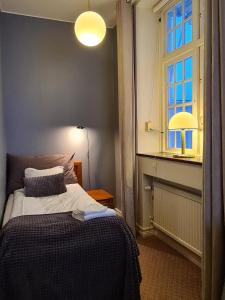 Habitación pequeña con cama y ventana en Furunäset Hotell & Konferens, en Piteå