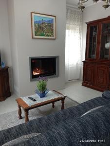 uma sala de estar com lareira e uma mesa de centro em La casa sul poggio em Lubriano