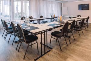 ein großer Konferenzraum mit einem langen Tisch und Stühlen in der Unterkunft Hotel Royal in Timmendorfer Strand