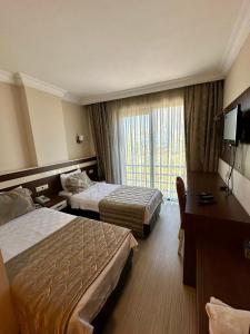 een hotelkamer met 2 bedden en een raam bij Hotel Avci in Bulancak