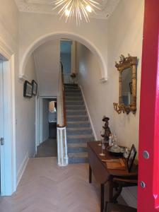 a hallway with a staircase with a mirror and a table at Eglinton Road - Sleeps 6 on room only basis in Bray