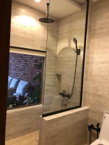 een douche met een glazen deur in de badkamer bij شاليه غيمه رذاذ in Diriyah