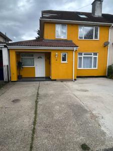a yellow house with a driveway in front of it at Blissful 1-bedroom entire place in Cambridge
