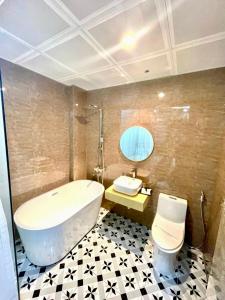 La salle de bains est pourvue d'une baignoire, de toilettes et d'un lavabo. dans l'établissement Grand Ha Noi Hotel, à Hanoï