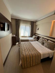 a hotel room with two beds and a television at Hotel Avci in Bulancak