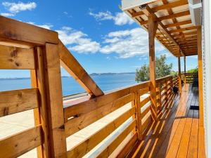 una terraza de madera con vistas al océano en d-view Premium Mobile Home - panoramic seaview - 150 m from beach, free parking, en Drage
