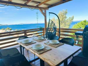 a wooden table with plates and glasses on a balcony at Mobile home d-view in Drage +45 photos