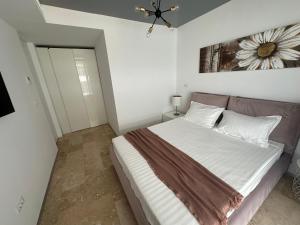 a bedroom with a bed and a painting on the wall at Astria by the Sea Apartment in Olimp