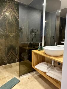 a bathroom with a sink and a shower at Astria by the Sea Apartment in Olimp