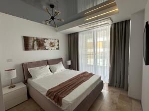 a bedroom with a bed and a large window at Astria by the Sea Apartment in Olimp