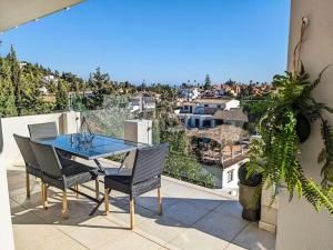 patio con mesa y sillas en el balcón en Panoramic views & pool. 4 mins to beach, en Santa Fe de los Boliches