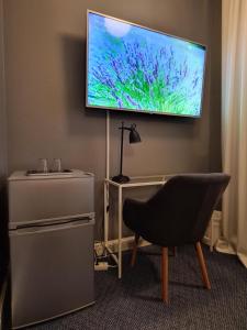 a living room with a chair and a flat screen tv at Furunäset Hotell & Konferens in Piteå