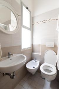 a bathroom with a sink toilet and a mirror at Abc Hotel in Rimini