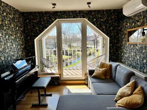 - un salon avec un canapé et un piano dans l'établissement Vana-Rääma Villa, à Pärnu