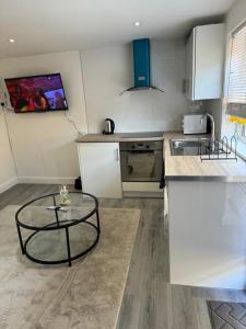 a kitchen with a glass table and a counter at Exclusive Lakeside Apartment in Grays Thurrock