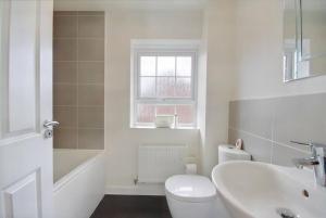 biała łazienka z toaletą i umywalką w obiekcie Cozy Casa: A Home Away from Home 
