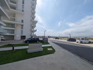 a parking lot with cars parked next to a building at Sea view Penthouse ABELIA 12 floors iskele Cyprus in Iskele