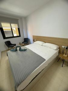 - une chambre avec un grand lit et deux chaises dans l'établissement Apartament Mar Beach Lloret, à Lloret de Mar