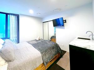 a bedroom with a bed and a tv on the wall at 2023 Stylish Central Apt+ Free Parking in Wellington