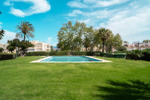 a swimming pool in the middle of a grass field at Sunstay Seaview Guadalmar in Málaga