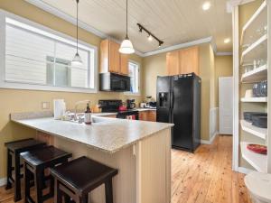 a kitchen with a black refrigerator and wooden floors at The Zinnia Victorian Charm with Mountain Views in Leadville
