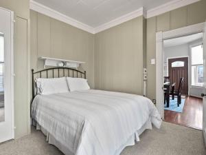 ein Schlafzimmer mit einem großen weißen Bett und einem Tisch in der Unterkunft The Zinnia Victorian Charm with Mountain Views in Leadville