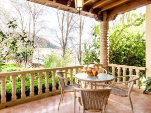 patio con mesa y sillas en el balcón en Casa rosa del romeral, en Nigüelas