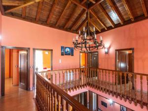a room with a staircase with a chandelier at Casa rosa del romeral in Nigüelas