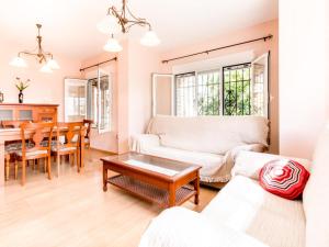 sala de estar con sofá y mesa en Casa rosa del romeral, en Nigüelas