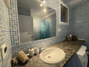 łazienka z umywalką i przeszkloną kabiną prysznicową w obiekcie Palm Garden Apartment w mieście Morro del Jable