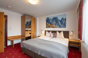 una habitación de hotel con una cama grande y montañas en Appartements Herold, en Söll