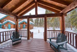 2 sillas sentadas en un porche de madera con nieve en Trapper`s Treasure 5B en Leadville