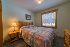 - une chambre avec un lit et une table avec une lampe dans l'établissement Trapper`s Treasure 5B, à Leadville