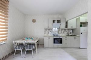 a kitchen with white cabinets and a table and chairs at Palas Suite 12 in Istanbul